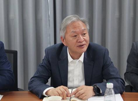 桌子前坐着穿西装的男子
描述已自动生成
